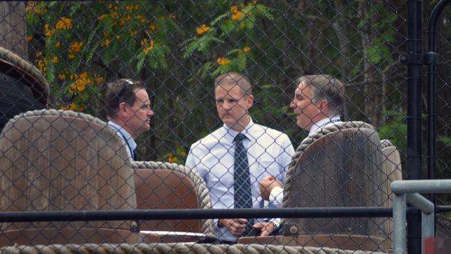 Police detectives are seen behind one of the rafts from the Thunder River Rapids ride at the Dreamworld theme park on the Gold Coast, Tuesday, Nov. 1, 2016. (AAP Image/Ed Jackson)