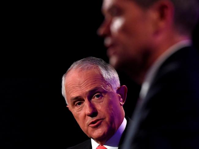 Prime Minister Malcolm Turnbull, left, speaks as Opposition Leader Bill Shorten listens at the leaders' debate at the National Press Club in Canberra, Sunday, May, 29, 2016. Australia will go to the polls on July 2, 2016 to elect a new prime minister after the Governor-General was asked to dissolve both houses of Parliament and call a full election. (AP Photo/Tracey Nearmy, Pool)