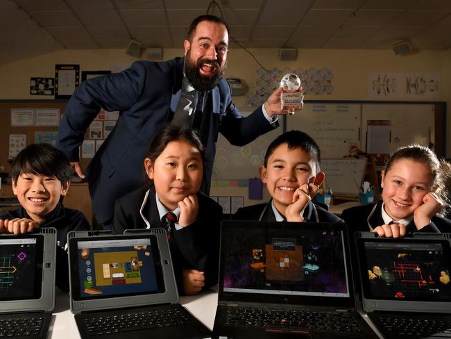 St Andrews Primary School students Vinh Huynh 9, Annabelle Sun 10, Karl Stals 10, Ava Cabot 10 with teacher Paul Huebl holding the trophy on the 28th July, 2020. STORY: SA primary school students take out top spot in a global crictical thinking competition: Adelaide students prove they are the smartest in the world! Picture: Tricia Watkinson