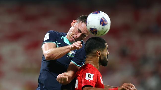 Socceroos defender Lewis Miller (left) gets the better of Bahrain’s Abdulla Al Khalasi in an aerial duel. Picture: Christopher Pike/Getty Images