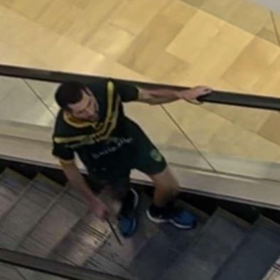 A man is seen on an escalator brandishing a large knife. He is later seen on the floor.