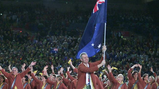 Andrew Gaze was all smiles as he carried the flag.