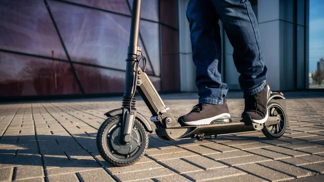 Close up view of legs of man on electric scooter