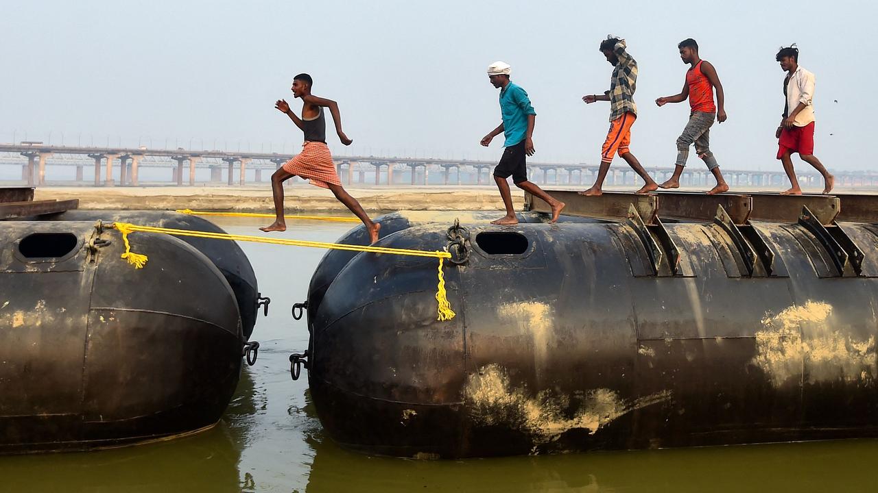 Labourers build a floating pontoon bridge ahead of the upcoming Hindu religious fair 'Magh Mela', along the shores of Ganges River in India. Picture: Sanjay Kanokia/AFP