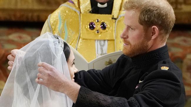 Harry adjusts his bride’s veil. Credit: AFP Photo/Pool/Owen Humphreys