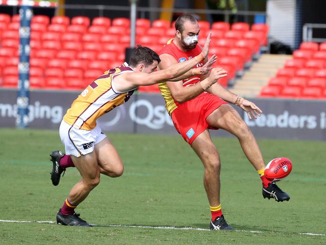 Round 4 NEAFL game between the Gold Coast Suns and Brisbane Lions at Metricon Stadium. Photo of Brayden Crossley kicking under pressure.