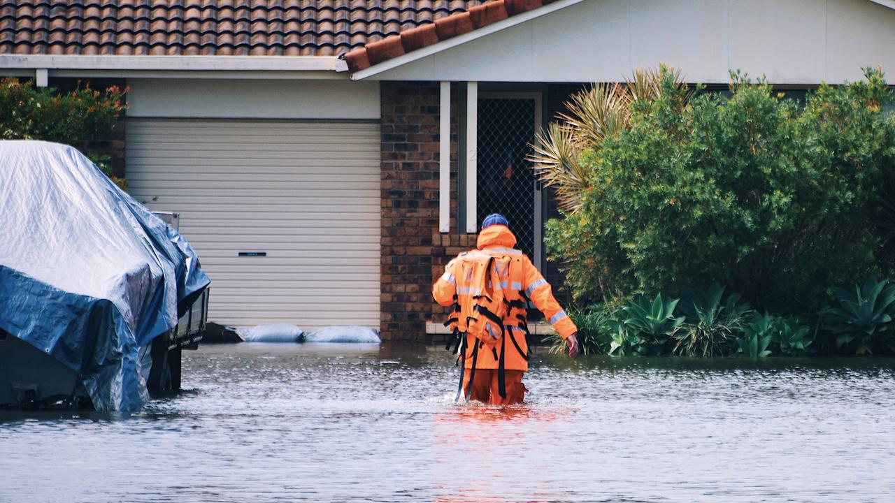 WEST BALLINA: SES trudge through floodwaters at West Ballina doorknocking residents on Monday March 30, 2022. Picture: Tessa Flemming.