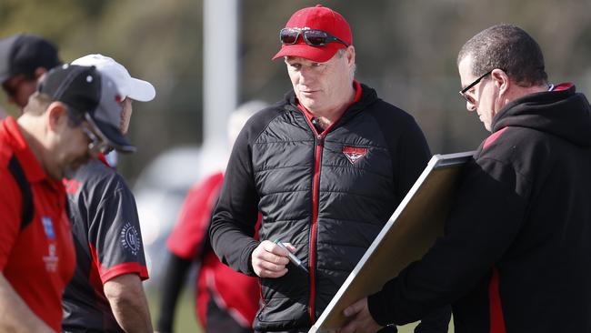 Darren Winter talks tactics with his assistants. Picture: Zak Simmonds