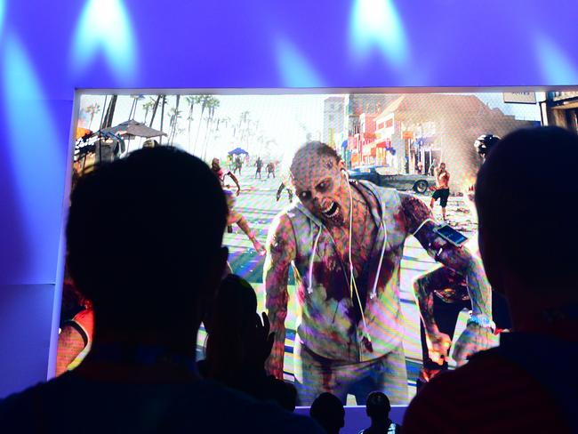 We are what we pretend to be ... gaming fans watch a preview of the game 'Sunset Drive' at the annual E3 video game extravaganza in Los Angeles, California. Picture: Frederic J Brown