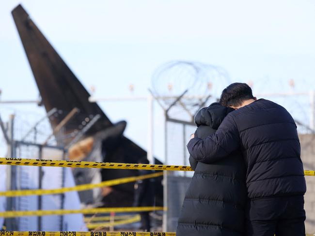 Bereaved family members stand at the scene where a Jeju Air Boeing 737-800 series aircraft crashed and burst into flames at Muan International Airport. Picture: AFP