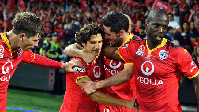 Fan favourite Pablo Sanchez is mobbed by his Adelaide United teammates after his late strike seals the Reds’ breakthrough championship. Picture: Daniel Kalisz/Getty Images