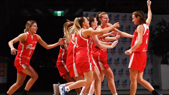 Jo Hill raises her arms in victory and is rushed by her teammates after the final buzzer as North Adelaide beat Forestville in the women’s Premier League decider on Saturday night. Picture: AAP/Mark Brake.