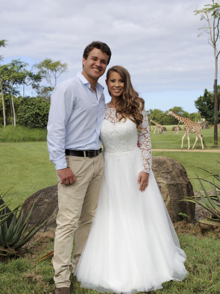 Chandler Powell and Bindi Irwin on their wedding day with giraffe in the background. Picture: Kate Berry