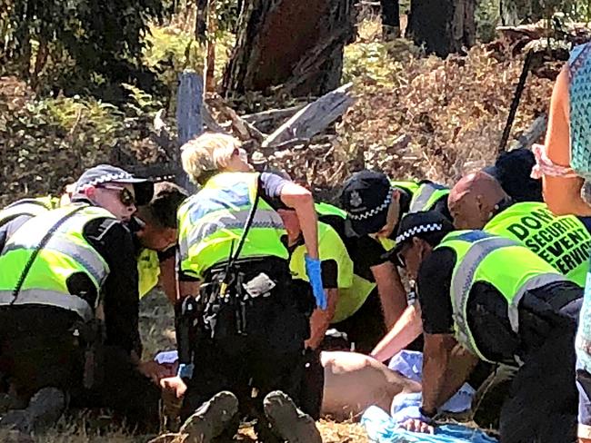 Emergency services attend to a man before he is loaded into an ambulance.  Rainbow Serpent Festival.  Picture: No byline please.