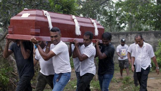 Relatives carry a coffin during the funerals of three people of the same family who were killed in the bombings. Picture: AP 