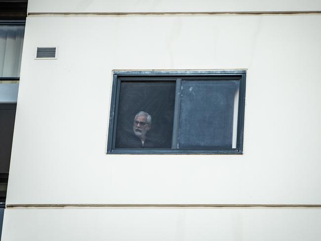 A resident looks out from his unit. Picture: Julian Andrews