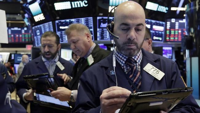 Fred DeMarco, right, works with fellow traders on the floor of the New York Stock Exchange on Friday. (AP Photo/Richard Drew)