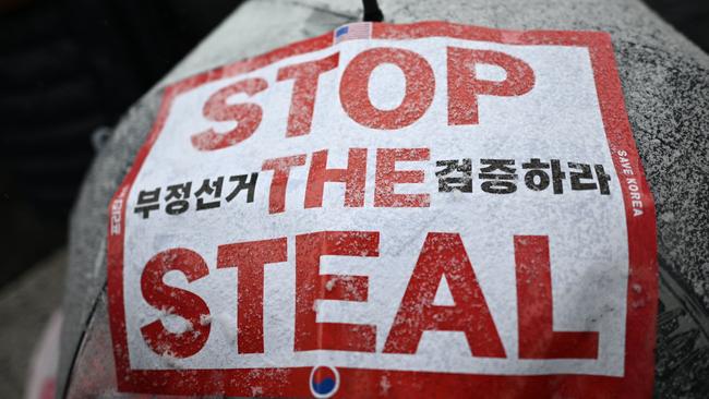 Snow is seen on a demonstrator's umbrella with a placard that reads "Stop the Steal", as supporters of impeached South Korea President Yoon Suk Yeol gather for a rally near Yoon's residence as snow falls in Seoul on January 5, 2025. Thousands of South Korean protesters braved a snowstorm January 5 over suspended President Yoon Suk Yeol who was still resisting arrest over a failed martial law bid less than 48 hours before the warrant expires. (Photo by Philip FONG / AFP)