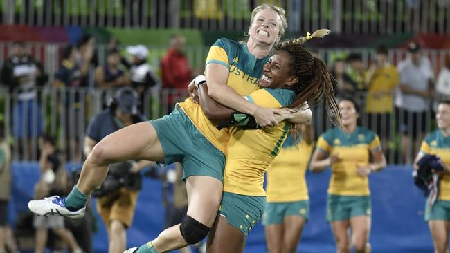 Ellia Green lifts up a teammate as they celebrate victory in the women’s rugby sevens gold. Picture: AFP Photo