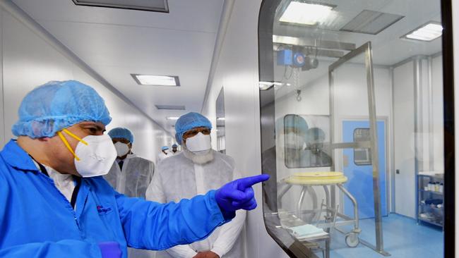 This handout photograph taken on November 28, 2020 and released by the Indian Press Information Bureau (PIB), shows Indiaâ&#128;&#153;s Prime Minister Narendra Modi (C) visiting the Zydus Biotech Park, a vaccine manufacturing facility, to review the Covid-19 coronavirus vaccine development in Ahmedabad. (Photo by - / INDIAN PRESS INFORMATION BUREAU / AFP) /