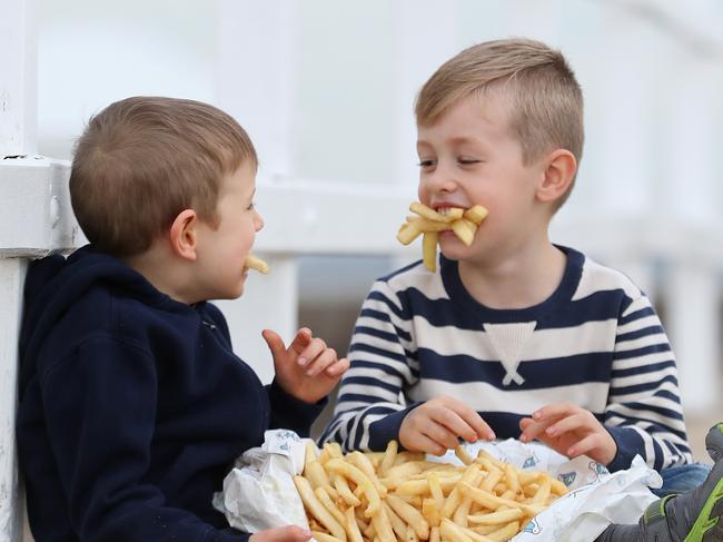 Thomas Prout (5) and friend Timothy Behan (5) enjoying some hot chips by the bay at Manly. Pic Peter Wallis