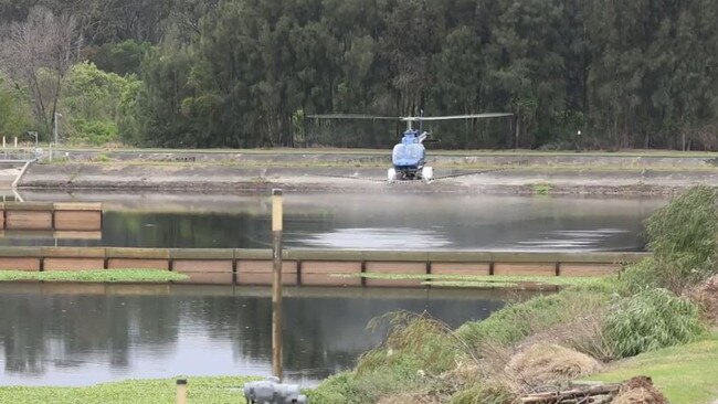 A helicopter sprays larvicides at Sydney Water' sLiverpool Water Resource Recovery Facilityat Warwick Farm. Picture: Sydney Water