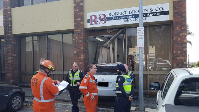 SES and Knox police officers discuss this afternoon's incident after a car smashed into an office at Wantirna Mall. Picture: KIEL EGGING