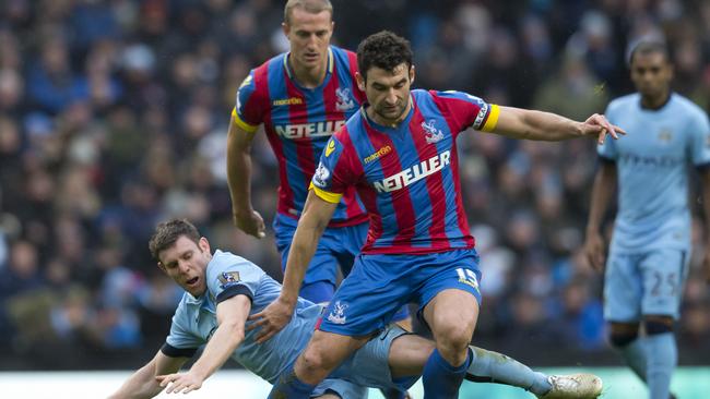 Manchester City's James Milner, bottom, fights for the ball against Mile Jedinak.