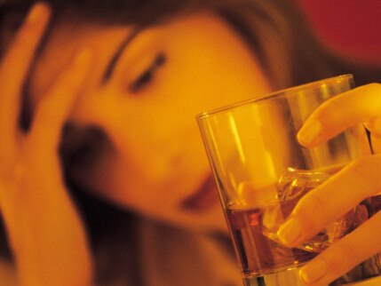 Stressed woman holding alcoholic drink.