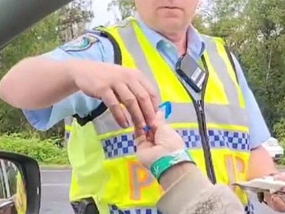 NO GLOVES: An image supplied by Greens MP Cate Faerhmann, which she said was taken by a staff member, allegedly shows the police officer conducting the RDT not wearing latex gloves, as she headed into Mardigrass on May 2, 2021. Image supplied