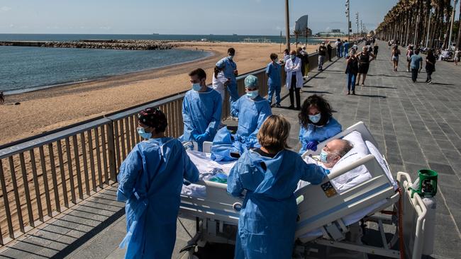 Health care staff at Barcelona’s Hospital del Mar take recovering COVID-19 patients from the ICU to the seaside as part of their recovering process. Picture: David Ramos/Getty Images