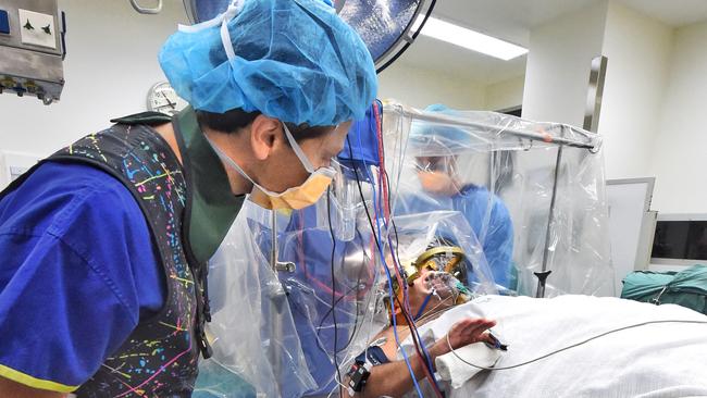 Neurologist Wes Thevathasan speaks to patient Grant Rowe as he undergoes Deep Brain Stimulation for Parkinson’s disease at St Vincent’s Private Hospital. Picture: Tony Gough