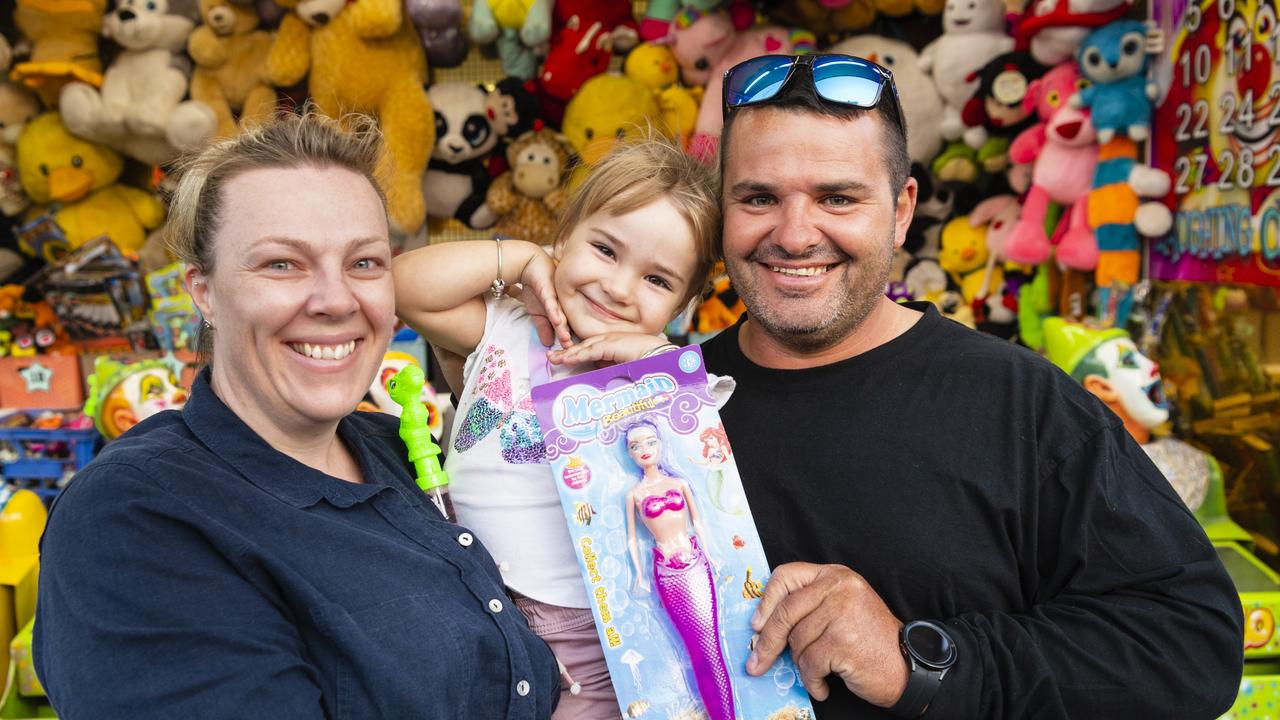 Ruby-Jane Hopper, with parents Rebecca Asgill and Reg Hopper, won a mermaid barbie in sideshow alley at the Toowoomba Royal Show, Thursday, March 30, 2023. Picture: Kevin Farmer