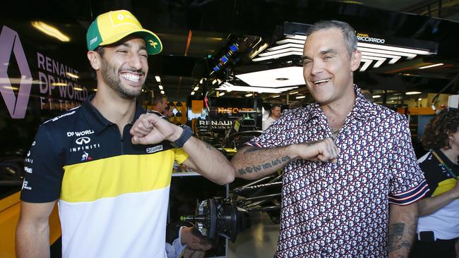 Daniel Ricciardo and Robbie Williams catch up in the Renault Pit Garage giving each other an anti-coronavirus elbow tap. Picture: David Caird