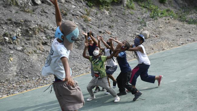 Masks are becoming the new normal amid the ongoing COVID-19 pandemic. Children are seen wearing masks during a basketball play at a court in La Guaira, Venezuela. Picture: AP Photo/Matias Delacroix