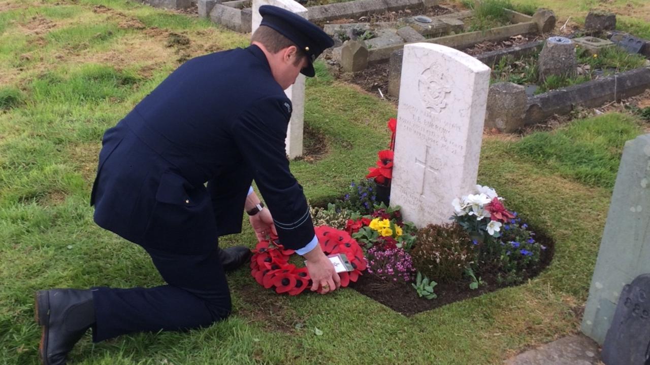 RAAF Flight Lt Adam Gunthorpe lays a wreath on the grave of Warrant Officer John Burrows on Anzac Day, 2018.