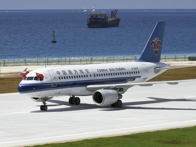 Pilots place Chinese national flags on the cockpit window of China Southern Airlines' passenger jet after it successfully test landed at an airport on the Meiji reef of the Nansha Islands in the South China Sea. Picture: Chen Yichen/Xinhua