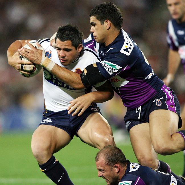 Corey Parker is tackled by Greg Inglis and Scott Hill during the 2006 NRL Grand Final match between the Broncos and Melbourne Storm.