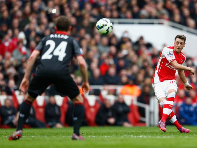 Arsenal playmaker Mesut Oezil curls the ball past Liverpool midfielder Joe Allen and into the net.