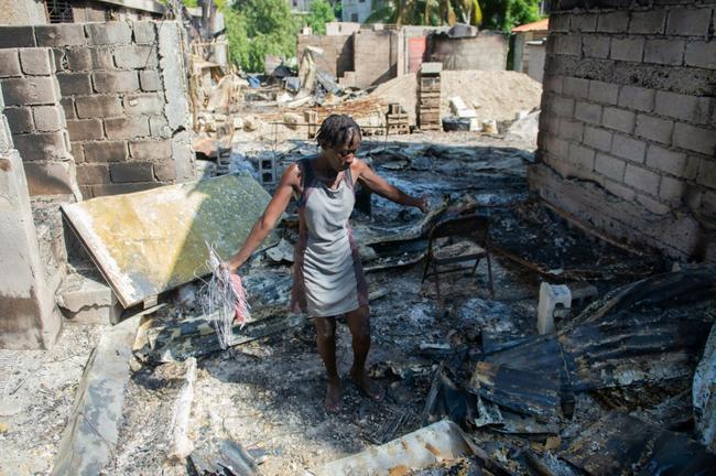 A woman looks through the burned remains of her home in the Solino district of the Haitian capital Port-au-Prince, on November 16, 2024, a day after gangs took over the area