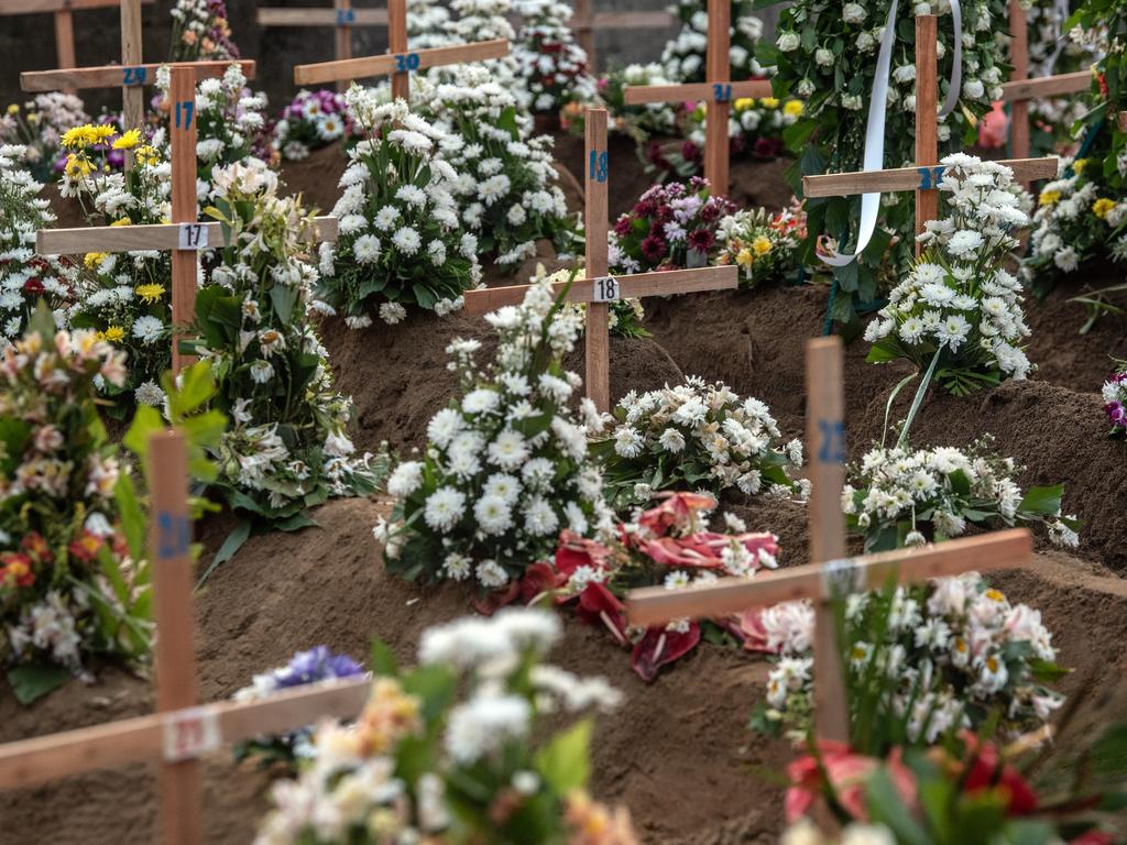 Makeshift wooden crucifixes mark the graves of people killed inside St Sebastian’s Church. Picture: Carl Court/Getty Images