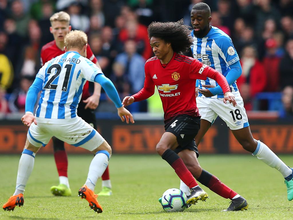 HUDDERSFIELD, ENGLAND - MAY 05: Tahith Chong of Manchester United is challenged by Alex Pritchard of Huddersfield Town during the Premier League match between Huddersfield Town and Manchester United at John Smith's Stadium on May 05, 2019 in Huddersfield, United Kingdom. (Photo by Alex Livesey/Getty Images)