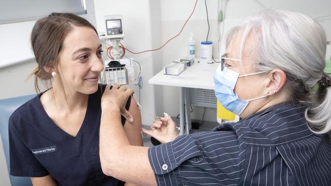 Registered nurses Jen Ives receives a Pfizer COVID-19 vaccine from Tracey Coppleman at the Royal Hobart Hospital. Picture: Chris Kidd