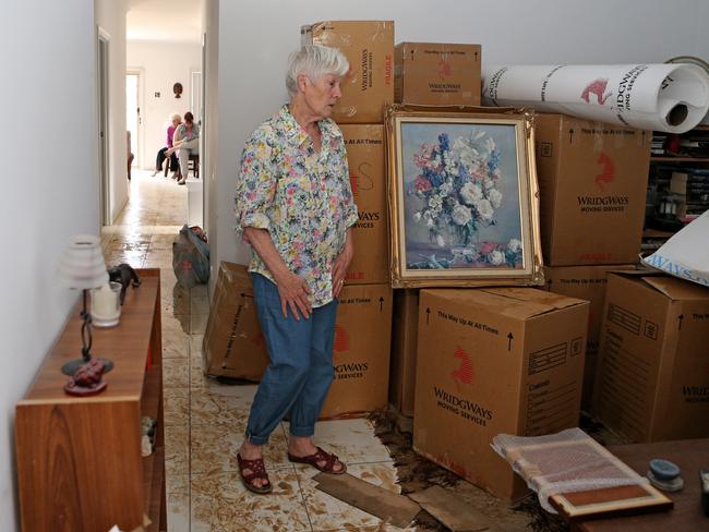 Huberta Puyverman looks at her destroyed belongings, after a burst water main flooded her home at Seacomb Gardens.