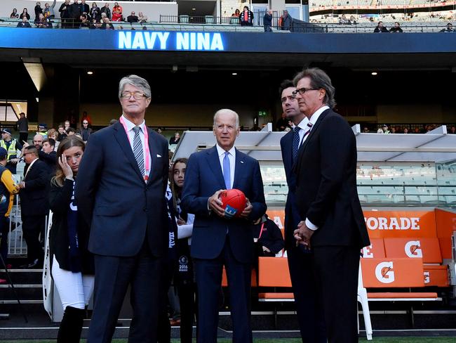 Then-US Vice President Joe Biden (centre) holds up and AFL football in 2016 at the MCG with then-AFL CEO Gillon McLachlan, Mike Fitzpatrick (right) and then-Chair of the MCC Steven Smith (left).