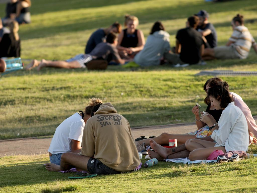 Groups of people sit on the grass at the south end of a closed Bondi beach on Sunday. Picture: Damian Shaw