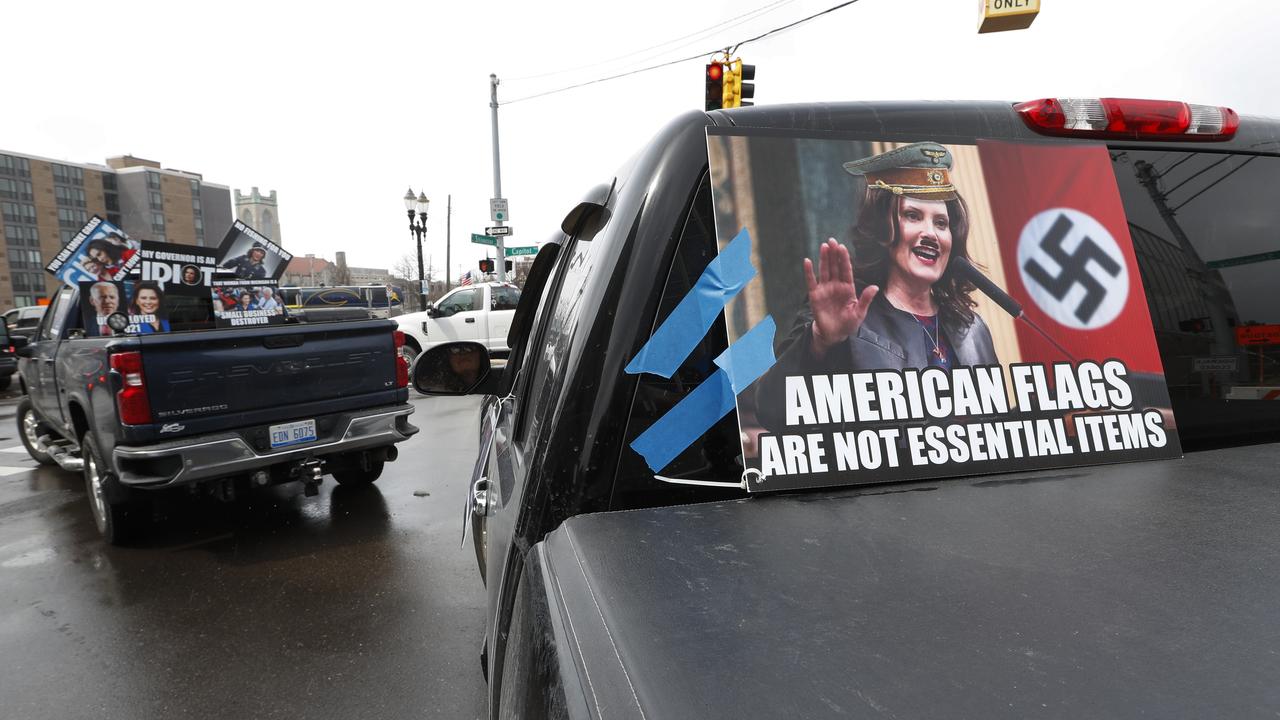 Signs showing Michigan Governor Gretchen Whitmer are taped to vehicles during a protest in Lansing. Picture: Paul Sancya