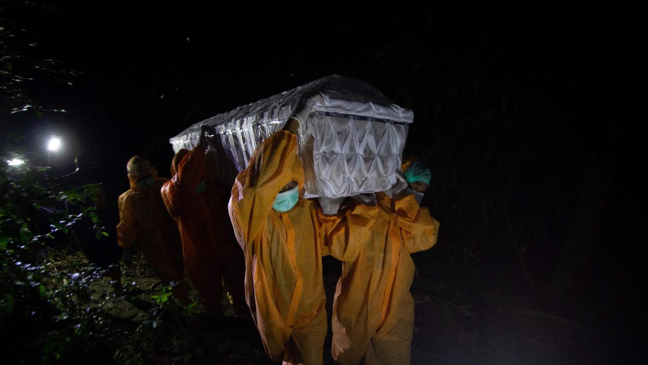 Gravediggers carrying a coffin of a man who died from Covid-19 while isolating at home in Ungaran, Central Java. Picture: AFP