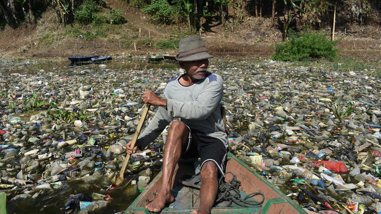 A scavenger paddles his boat to collect plastic waste on the Citarum River choked with garbage and industrial waste, in Bandung, West Java. Photo: Timur Matahari/AFP