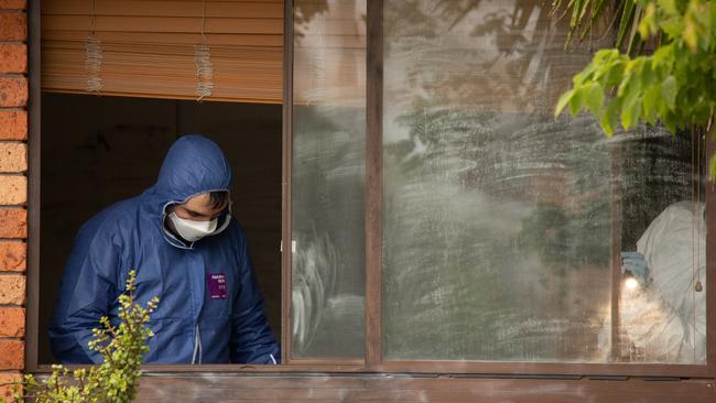 Forensic police comb over a window at the Cranebrook home where the woman’s body was found.